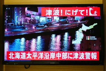 Un avertissement indiquant "Tsunami ! Courez !" (en haut) et "Alerte au tsunami émise pour la côte Pacifique du centre de Hokkaido" s'affiche sur un écran de télévision à Sapporo, au Japon, le 9 décembre 2025