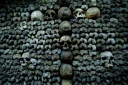 Des crânes et des ossements humains alignés contre un mur des catacombes de Paris, le 24 mars 2026