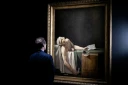 Un visiteur devant le tableau "La mort de Marat" (également connu sous le nom de "Marat Assassiné") du peintre français Jacques-Louis David, le 14 octobre 2025 au musée du Louvre à Paris