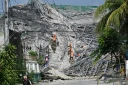 Des militaires accompagnés d'un chien fouillent les décombres d'un immeuble effondré à Angeles City, dans la province de Pampanga, au nord de Manille, le 25 mai 2026 aux Philippines