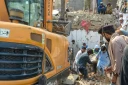 Des personnes transportent le corps d'une victime après un attentat contre un poste de contrôle de police à Bannu, dans le nord-ouest du Pakistan, le 10 mai 2026