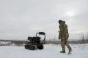 Un militaire ukrainien de la 30e brigade mécanisée indépendante prépare un véhicule terrestre robotisé sans pilote armé d'un lance-grenades Mk 19 pour un test dans un lieu non divulgué de la région de Donetsk le 27 janvier 2026.
