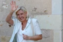 Marine Le Pen, cheffe du groupe parlementaire Rassemblement national (RN) et candidate à la présidentielle de 2027, salue ses sympathisants après une réunion de campagne à l'hôtel de ville de La Flèche, le 8 juillet 2026 dans la Sarthe