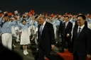 Le président américain Donald Trump (c) accompagné par le vice-président chinois Han Zheng (d) à son arrivée à l'aéroport international de Pékin, le 13 mai 2026