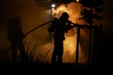 Des pompiers luttent contre un incendie devant un camping à Villeneuve-lès-Béziers, le 9 juillet 2026 dans l'Hérault