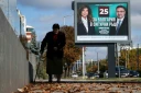 Une personne marche devant une affiche électorale de la présidente sortante de Bulgarie, Iliana Iotova, et de son vice-président candidat Kiril Valchev, à Sofia, le 23 octobre 2026