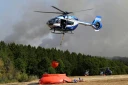 Des hélicoptères de la police chargent de l'eau pour lutter contre un incendie de forêt à Hurtgenwald, dans l'ouest de l'Allemagne, le 14 août 2026