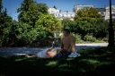 Des personnes sont allongées sur l'herbe à l'ombre place de la Nation, à Paris, le 28 juillet 2026, lors de la quatrième vague de chaleur en France