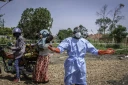 Dieudonné Sezabo, un agent de santé, demande de l'aide pour accueillir une jeune femme soupçonnée d'avoir la maladie Ebola, à l'hôpital de Rwampara, dans le nord-est de la République démocratique du Congo (RDC) le 26 mai 2026

