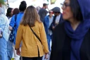 Des passants dont une femme sans voile dans la rue à Téhéran en Iran le 25 avril 2026