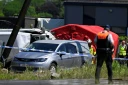 Un corbillard stationné sur le site d'un accident entre un train et un bus scolaire, au passage à niveau de Vierhuizen à Buggenhout, au nord de Bruxelles, le 26 mai 2026 en Belgique