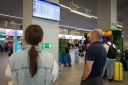 Des passagers regardent un panneau d'affichage des vols à l'aéroport de Kaliningrad, en Russie, le 4 juillet 2026
