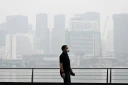 Un passant porte un masque de protection le long du boulevard à Marina Bay, noyé dans la brume, le 12 octobre 2026 à Singapour
