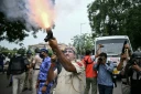 Un policier tire des grenades lacrymogènes pour disperser des militants du "Parti du peuple des cafards" (CJP) lors d'une manifestation réclamant la démission du ministre de l'Éducation, Dharmendra Pradhan, en raison de fraudes présumées aux examens universitaires, le 20 juillet 2026 à New Delhi, en Inde
