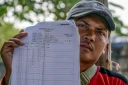Akhmad, ancien membre d'équipage d'un navire de pêche chinois, montre son contrat et son salaire mensuel lors d'un entretien avec l'AFP au port du hameau de Bungko Lor, à Cirebon, le 10 juin 2026 en Indonésie
