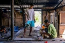Le noble Umbu Ana Rara (g) regarde son esclave (d) Kanisius Kanyali Hambarita préparer des boissons au village de Tanggedu, dans l'est de l'île de Sumba, le 23 juin 2026 en Indonésie