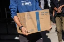 Un Palestinien porte un colis alimentaire fourni par le Programme alimentaire mondial le 27 octobre 2025 dans le centre de la bande de Gaza