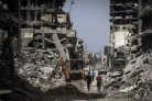 Des Palestiniens longent des bâtiments détruits dans une rue de Khan Younès, dans le sud de la bande de Gaza, le 23 avril 2024. ( AFP / - )