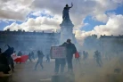 Des protestataires dans la fumée de gaz lacrymogènes lors d'une manifestation contre la vie chère place de la République à Paris, le 17 octobre 2026 ( AFP / Matthieu RONDEL )
