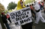 Un manifestant tient une pancarte en appelant aux gilets jaunes, le 13 octobre 2026 à Paris