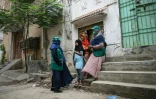 Des agentes de santé parlent à des adolescentes, lors d'une campagne de vaccination porte-à-porte contre le virus du papillome humain (VPH) responsable du cancer du col de l'utérus, le 24 septembre 2025 à Karachi, au Pakistan