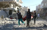 Des volontaires syriens transportent un blessé après des bombardements le 30 septembre 2016 sur la zone rebelle de Heluk à Alep