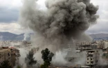Un nuage de fumée s'élève au-dessus de la localité de Kafr Batna dans la Ghouta orientale après un bombardement du régime syrien, le 22 février 2018