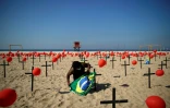 Un homme prépare une cérémonie d'hommage aux victimes du Covid-19, sur la plage de 
Copacabana à Rio de Janeiro (Brésil), le 8 août 2020