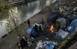 Des migrants se réchauffent autour d'un feu, le 23 février 2018 à Paris où un froid sibérien est attendu