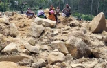 Des membres de la famille de villageois disparus sont présents sur le site d'un glissement de terrain au village de Mulitaka, dans la province d'Enga en Papouasie-Nouvelle-Guinée, le 26 mai 2024