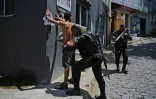 Un membre de la police militaire fouille un suspect pendant une opération contre le trafic de drogue dans la favela de Jacarezinho, le 19 janvier 2022 à Rio de Janeiro, au Brésil