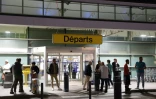 Des passagers attendent devant l'aéroport Napoléon Bonaparte d'Ajaccio, en Corse, le 3 octobre 2024