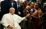 Le pape François offre des bonbons à un musicien lors d'une cérémonie de bienvenue à Port Moresby, en Papouasie-Nouvelle-Guinée, le 7 septembre 2024.