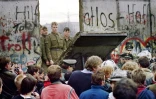 Des Allemands de l'Ouest à Berlin le 11 novembre derrière le mur alors que des gardes-frontières est-allemands détruisent une portion du mur