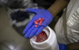 Un agent montre des comprimés rouges de tapentadol dans les locaux de l'Agence nationale de lutte contre la drogue (NDLEA) à Lagos, le 19 février 2026 au Nigeria