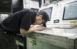 Un employé contrôle la qualité d'impression à l'imprimerie Kyoto Shimbun à Kumiyama, dans la préfecture de Kyoto, le 19 mars 2026 au Japon