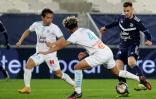Les défenseurs de Marseille, le Japonais Yuto Nagatomo (g) et le Français Boubacar Kamara (c), disputent le ballon à l'attaquant de Bordeaux, Rémi Oudin, lors du match de Ligue 1 à Bordeaux, le 14 février 2021
