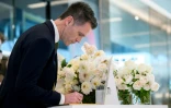 Le chef du gouvernement de la Nouvelle-Galles du Sud Chris Minns signe un livre de condoléances lors de la réouverture du centre commercial Westfield Bondi Junction à Sydney, le 18 avril 2024