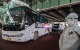 Un bus transportant les experts de l'OMS venus enquêter sur les origines de la pandémie quitte l'aéroport de Wuhan, le 14 janvier 2021 en Chine