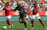 Le Lensois Séko Fofana (c) entre les Rémois Marshall Munesti (g) et Andreaw Gravillon, le 8 mai 2022 à Reims