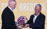 L'entraîneur de Brest Eric Roy reçoit le trophée de meilleur entraîneur de Ligue de la saison des mains du sélectionneur des Bleus Didier Deschamps le 13 mai 2024 à Paris