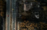 Des voitures circulent sur une route jouxtant des propriétés incendiées, à la suite d'un feu de forêt qui a fait rage en Gironde, à Lanton, le 4 août 2026