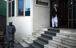 L'entrepreneur Shoaib Barak (d) et l'homme d'affaires Ehsanullah Maroof (g) devant l'entrée des bureaux de l'entreprise, le 18 décembre 2021 à Kaboul