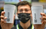 Un employé de la société Family Mart à Taipei, montre des gobelets réutilisables dotés de QR codes, le 31 octobre 2023
