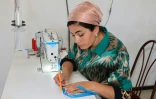 Une employée de "Tumush Kola" coud de la soie à Kattakourgan, le 3 juin 2024 en Ouzbékistan