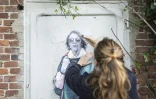 L'artiste de rue LaDame Quicolle installe un collage mural représentant Gisèle Pelicot, le 16 octobre 2024, à Lille