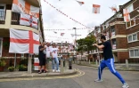Des habitants d'une résidence dans le sud de Londres, entourés de drapeaux d'Angleterre, le 10 juillet 2021 à la veille de la finale de l'Euro 2020 contre l'Italie