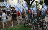 Des manifestants portent le drapeau israélien le 18 juillet 2023 à Tel-Aviv lors d'une journée de mobilisation contre un projet de réforme judiciaire controversé du gouvernement israélien