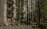 Des gens passent près d'immeubles d'habitations sérieusement endommagés par des frappes aériennes, à Kostyantynivka, dans la région orientale de Donetsk, le 20 avril 2025