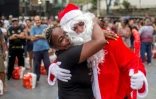 Une habitante de la favela Complexo do Alemao à Rio de Janeiro embrasse un père Noël pendant une distribution de repas gratuits, le 23 décembre 2021